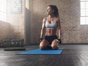  woman kneeling on an exercise mat