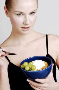  woman eats cereal with fruit