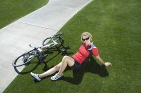 Cycling - an effective way to lose body fat. Health benefits of cycling 2 a woman sits next to a bike