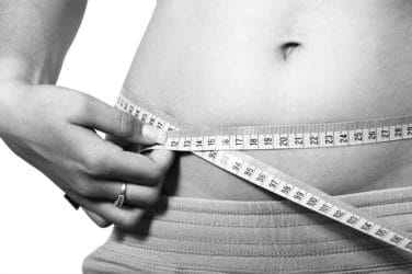  a woman measures her waist circumference