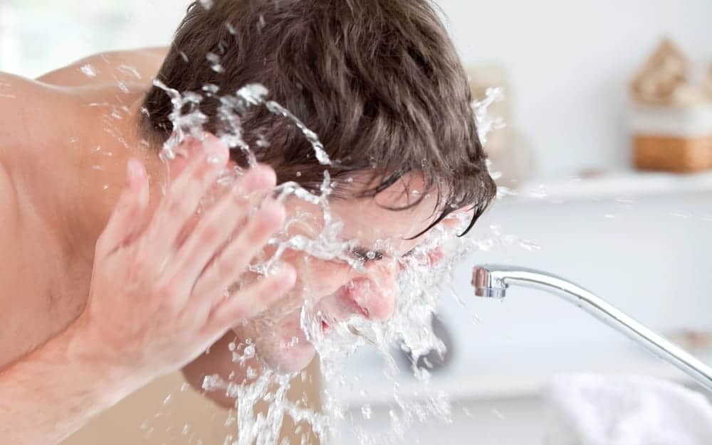 a man washes his face